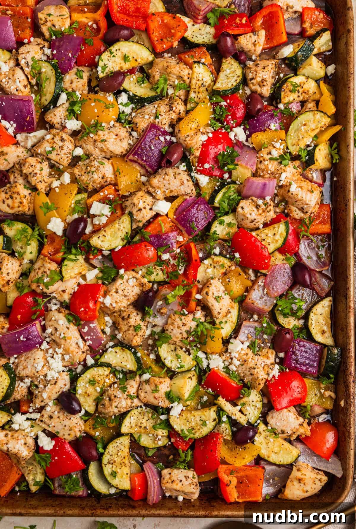 Greek-Style Sheet Pan Chicken Dinner with Lemon & Olives 2 Greek chicken sheet pan dinner topped with feta cheese and chopped parsley.