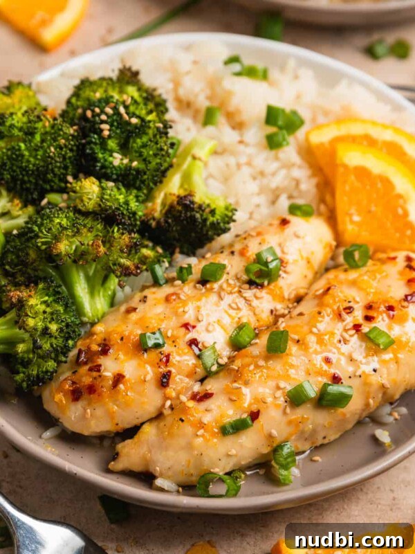 Greek-Style Sheet Pan Chicken Dinner with Lemon & Olives 14 Baked orange chicken sheet pan dinner served on plate with white rice and orange slices.