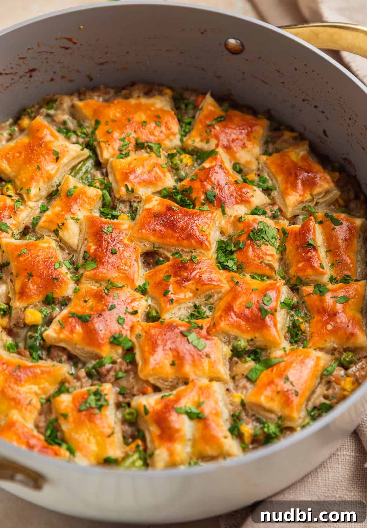 Savory Ground Turkey Pot Pie Recipe for Comforting Dinners 2 Ground turkey pot pie in pan with puff pastry on top.