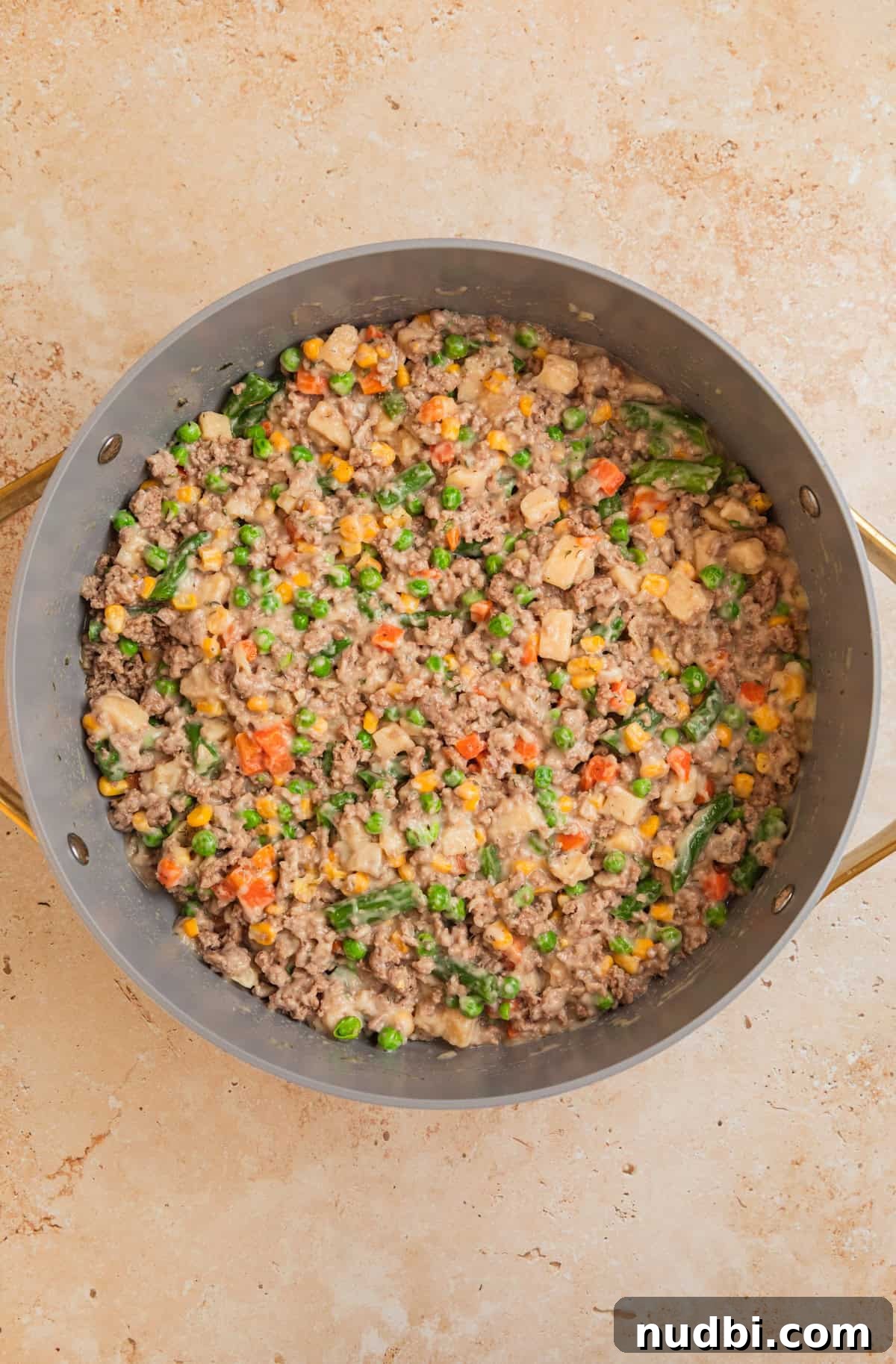 Savory Ground Turkey Pot Pie Recipe for Comforting Dinners 6 Pan with turkey pot pie mixture with vegetables and soup.