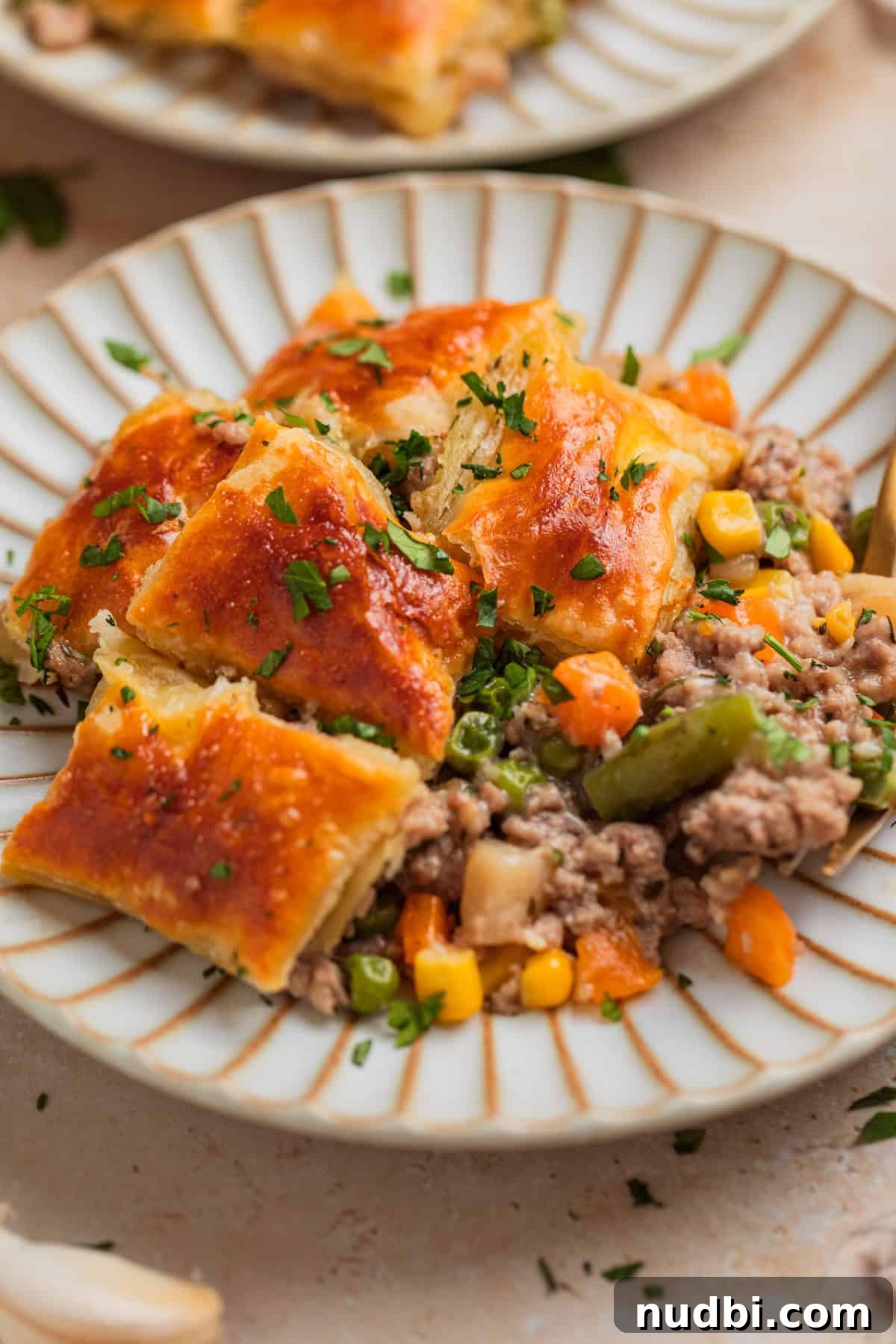 Savory Ground Turkey Pot Pie Recipe for Comforting Dinners 9 Plate with serving of turkey pot pie topped with puff pastry squares.