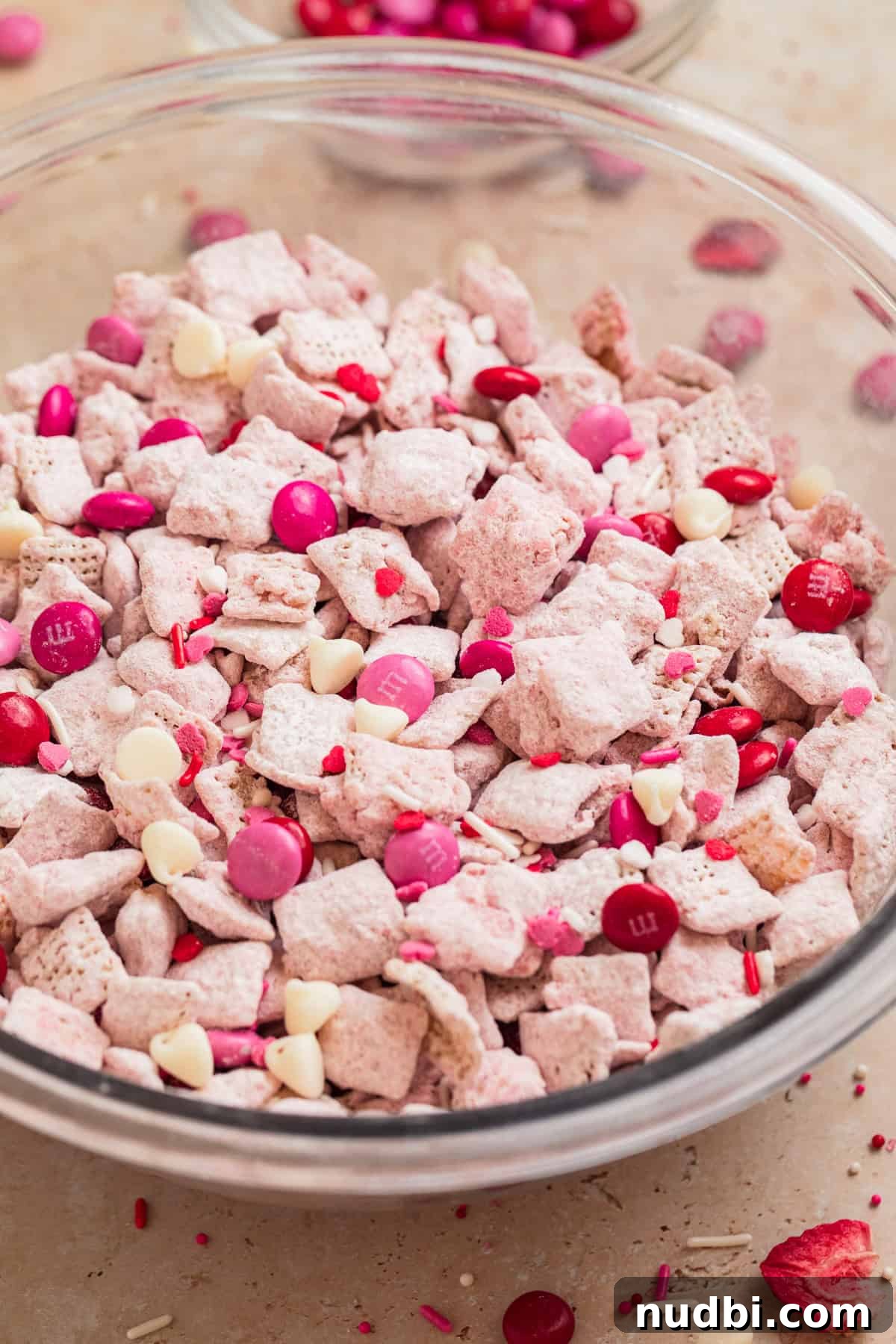Strawberry Chex Mix Recipe: Sweet, Crunchy Snack for Parties 2 Valentine's Day strawberry chex mix in bowl with red and pink m & M candies.