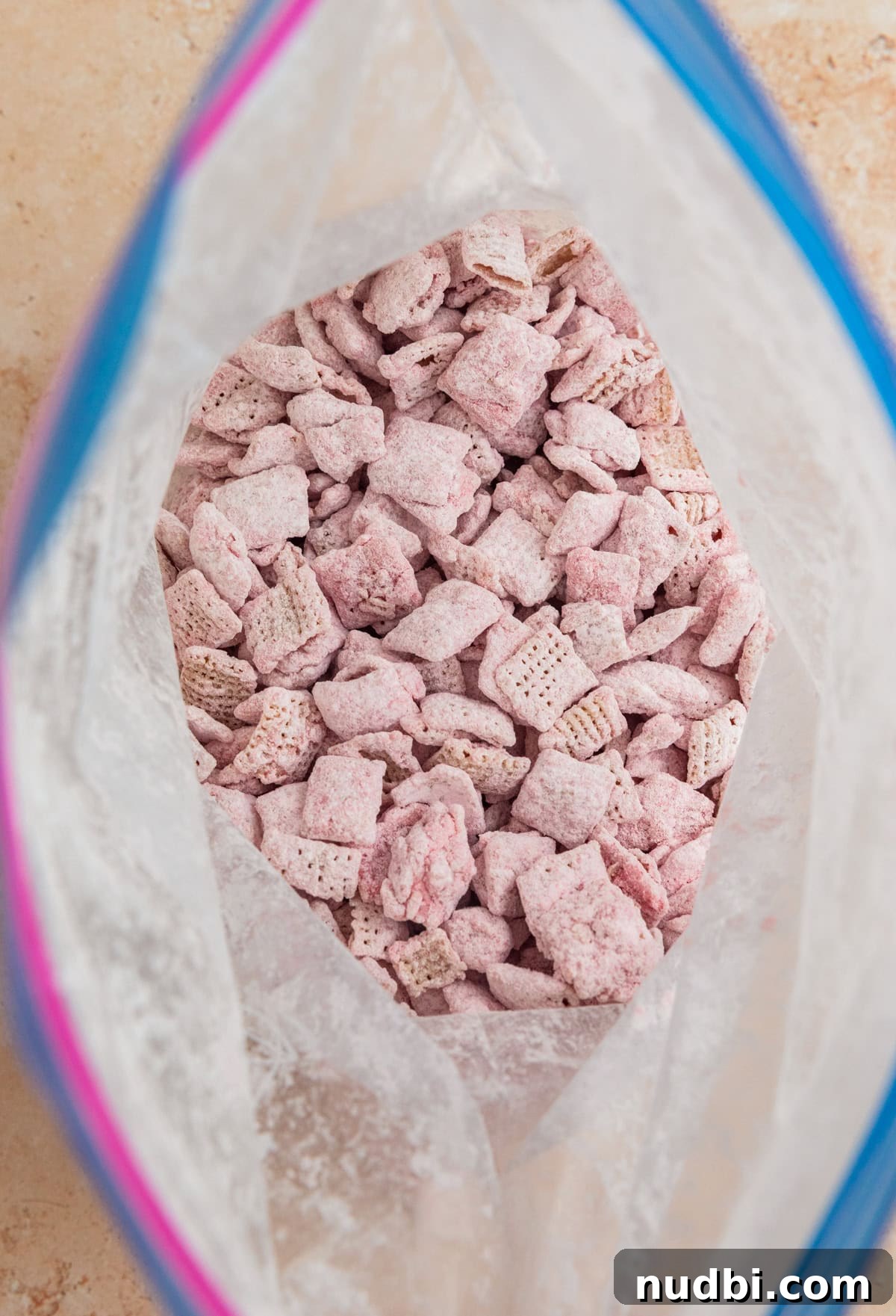 Strawberry Chex Mix Recipe: Sweet, Crunchy Snack for Parties 12 Strawberry puppy chow coated with powdered sugar in bag.