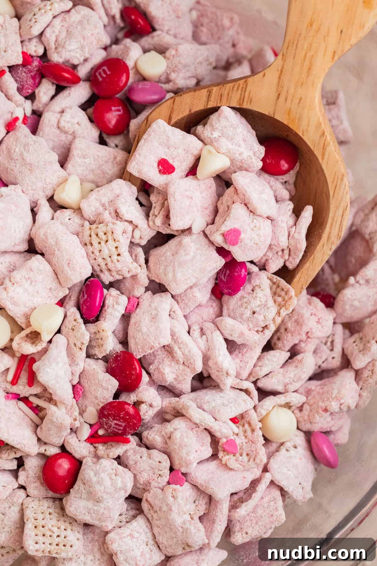 Strawberry Chex Mix Recipe: Sweet, Crunchy Snack for Parties 13 Bowl with strawberry puppy chow and wood scoop scooping into it