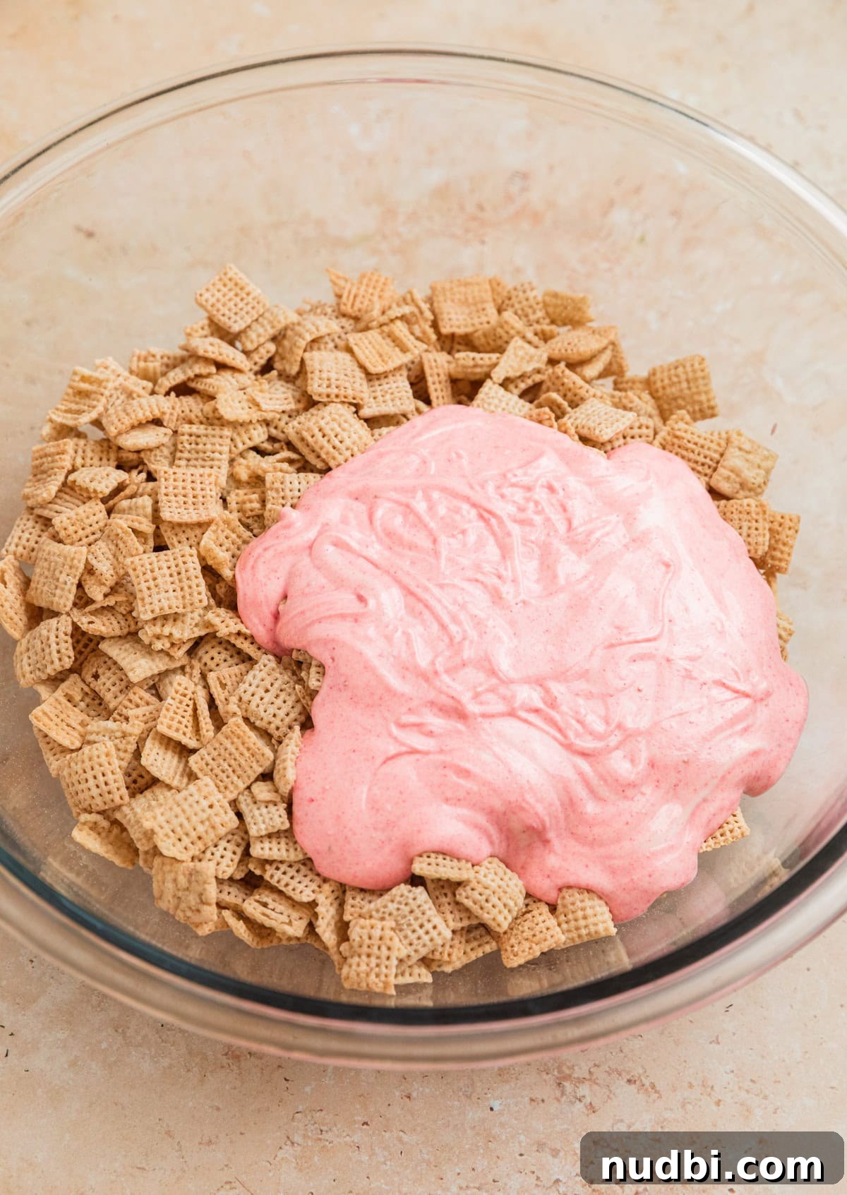 Strawberry Chex Mix Recipe: Sweet, Crunchy Snack for Parties 8 Melted strawberry white chocolate poured over rice Chex in mixing bowl.