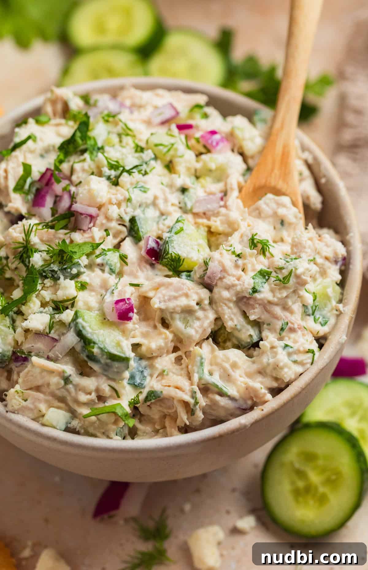 Cucumber, Feta & Chicken Salad with Lemon-Dill Dressing 2 Feta chicken salad with cucumbers and dill with spoon scooping into bowl.