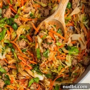 Pot with egg roll bowl made with ground turkey with wooden spoon propped in it.