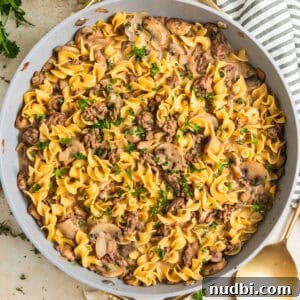 Skillet with beef stroganoff topped with chopped fresh parsley.