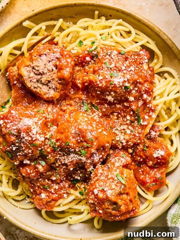 Spinach and Feta Turkey Meatballs with Garlic Herb Sauce 12 Plate with spaghetti and meatballs topped with fresh parmesan.