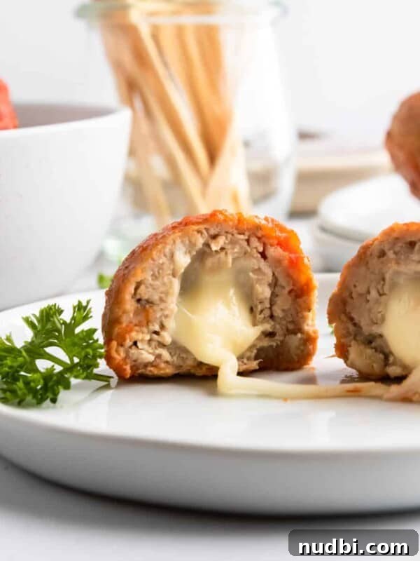 Spinach and Feta Turkey Meatballs with Garlic Herb Sauce 13 Mozzarella stuffed turkey meatballs on plate with cheese stretching.