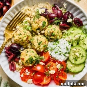 Spinach and Feta Turkey Meatballs with Garlic Herb Sauce 16 Spinach and feta turkey meatballs on plate with fork and topped with fresh herbs.
