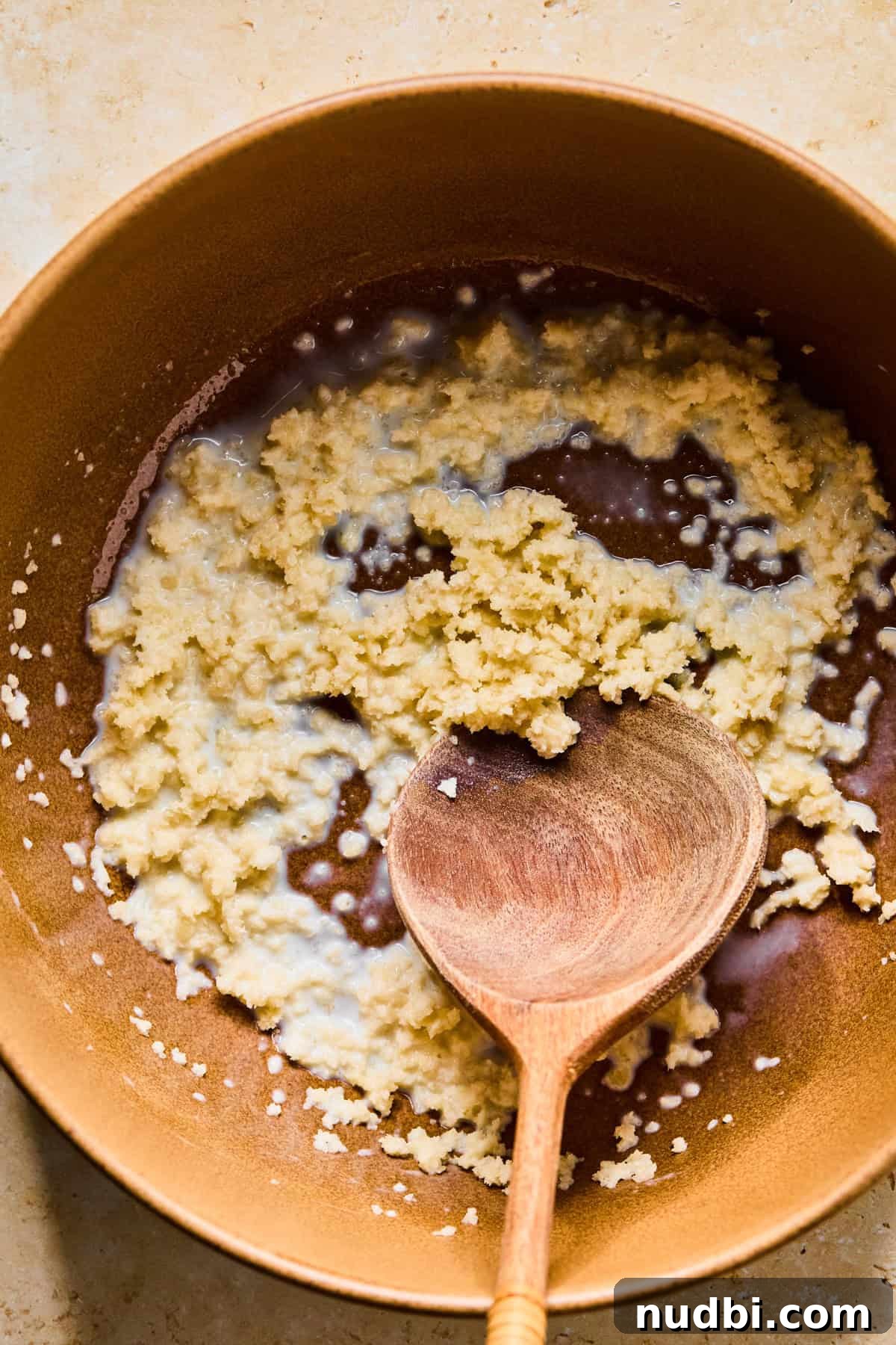 Spinach and Feta Turkey Meatballs with Garlic Herb Sauce 5 Milk and breadcrumbs in bowl with wooden spoon.
