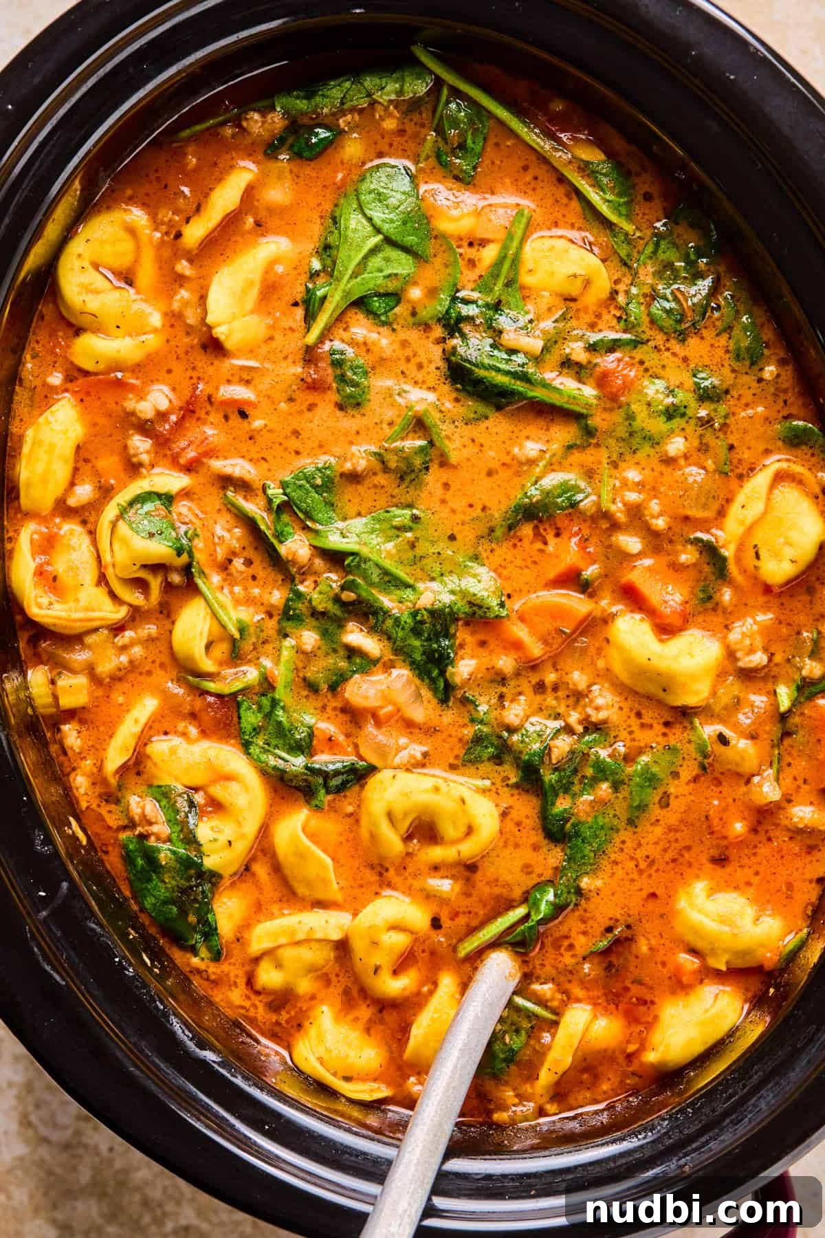 Slow-Cooker Sausage and Tortellini Soup Recipe 12 Sausage tortellini soup in slow cooker with ladle.