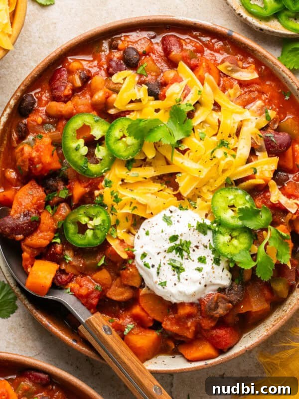 Slow-Cooker Sausage and Tortellini Soup Recipe 15 Bowl with vegetarian sweet potato chili with toppings and spoon propped to the side of the bowl.