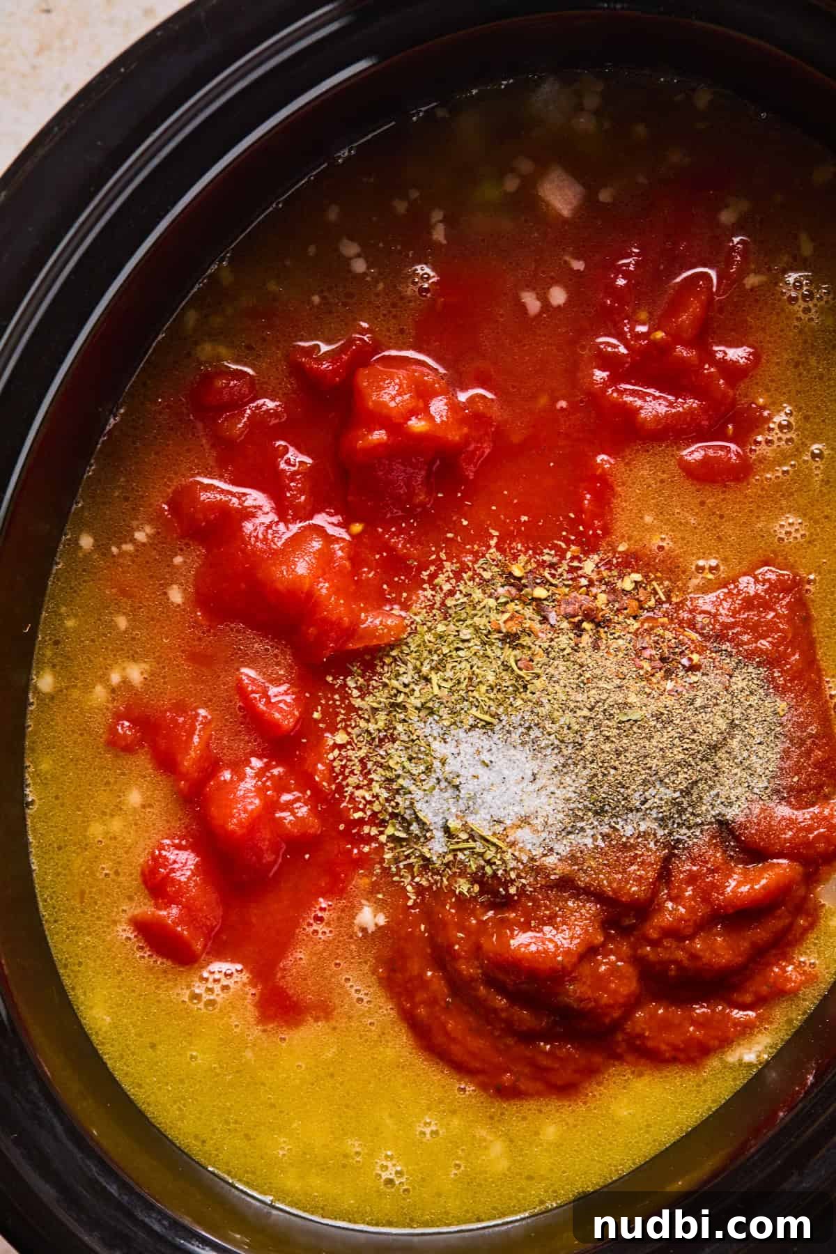 Slow-Cooker Sausage and Tortellini Soup Recipe 9 Broth, marinara, tomatoes, and spices added to slow cooker with meat and vegetables.