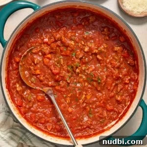 Ground turkey spaghetti sauce in pot with ladle.