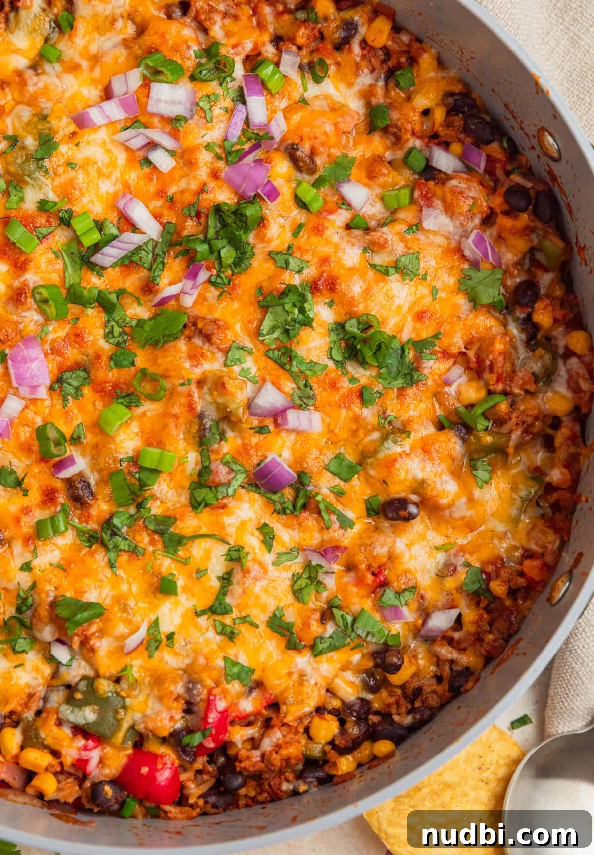 Cheesy Turkey Taco Skillet Dinner Recipe 2 Cheesy taco rice skillet topped with chopped cilantro, green onions and red onions.