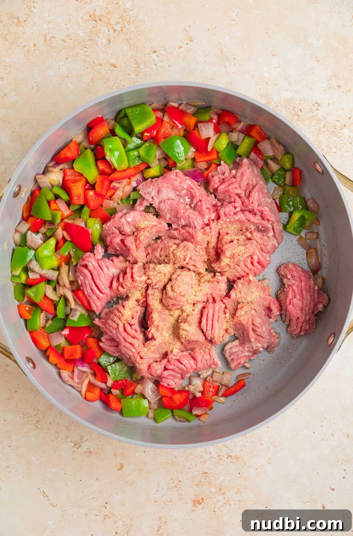 Cheesy Turkey Taco Skillet Dinner Recipe 5 Ground turkey added to skillet with sautéed onions and peppers.