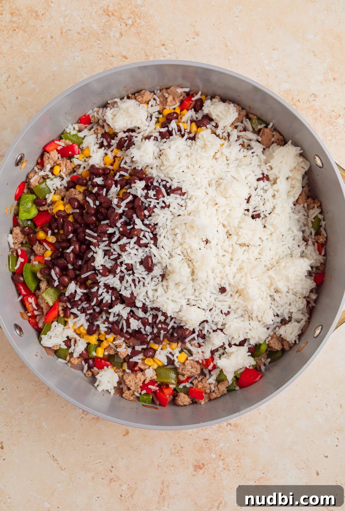 Cheesy Turkey Taco Skillet Dinner Recipe 7 Cooked rice, black beans, tomatoes and other ingredients added to pan with browned meat.