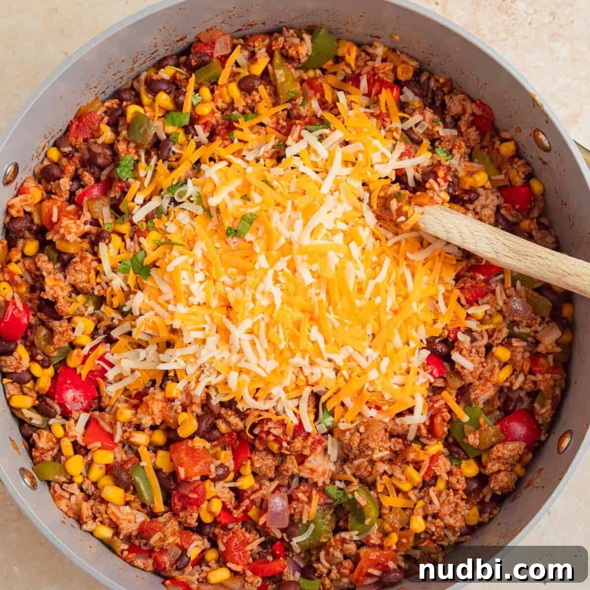 Cheesy Turkey Taco Skillet Dinner Recipe 8 Shredded cheese added to skillet with turkey rice taco ingredients.