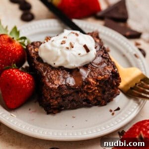 Decadent Chocolate Baked Oats Recipe for Breakfast and Snacks 10 Piece of chocolate baked oats on plate with yogurt on top.