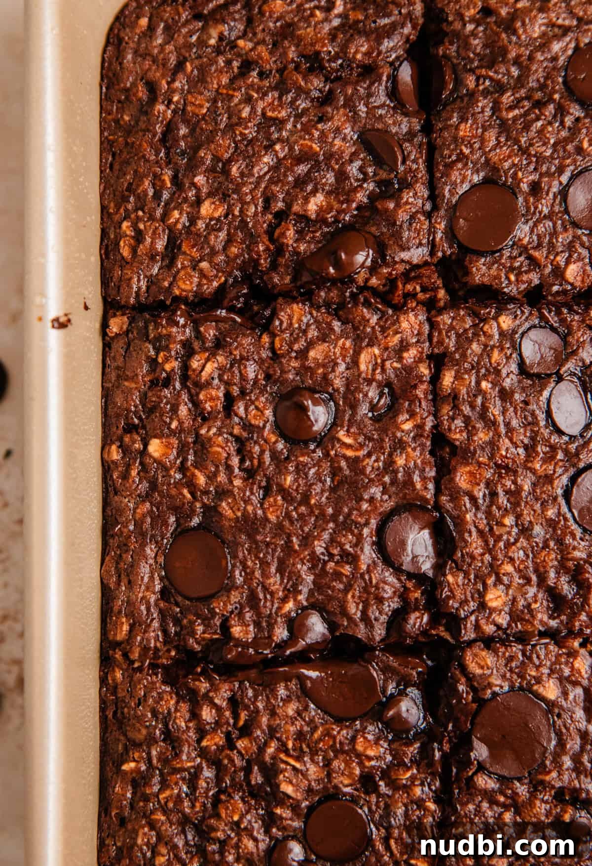 Decadent Chocolate Baked Oats Recipe for Breakfast and Snacks 9 Chocolate baked oatmeal with chocolate chips sliced and sitting in baking pan.