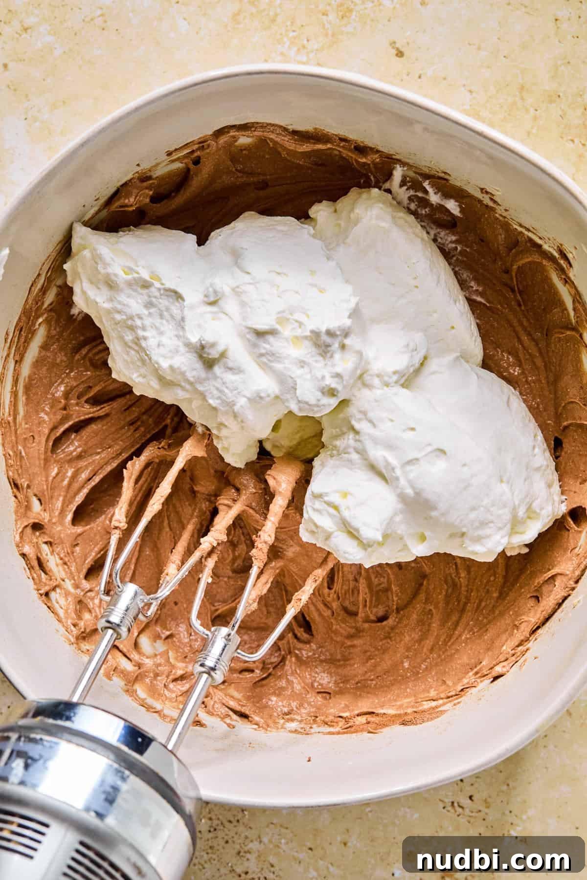 Decadent No-Bake Chocolate Icebox Cake Recipe 8 Cocoa cream cheese mixture with whipped cream dolloped into the bowl.