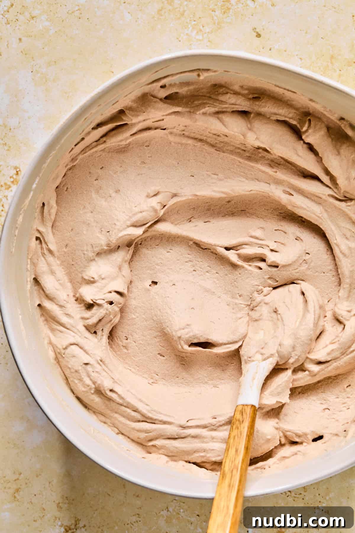 Decadent No-Bake Chocolate Icebox Cake Recipe 10 Creamy hot cocoa mixture with spatula in bowl.
