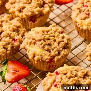 Strawberry muffins with crumb topping on wire rack.