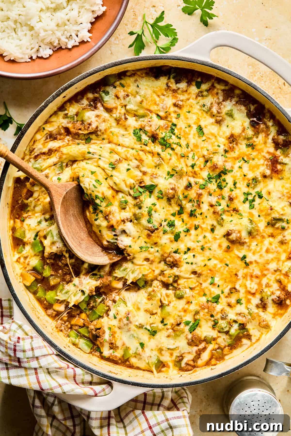 Philly Cheesesteak Rice Bowl Recipe — Savory Steak & Peppers 2 Philly cheesesteak bowls in skillet topped with cheese.