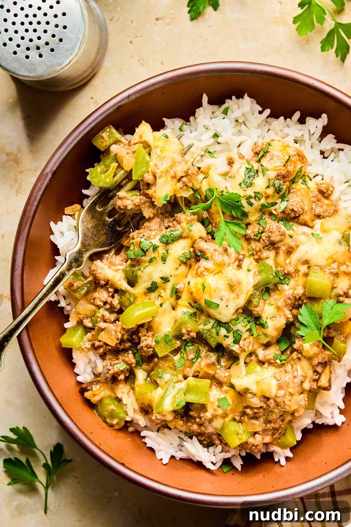 Philly Cheesesteak Rice Bowl Recipe — Savory Steak & Peppers 13 Philly cheesesteak rice bowl with fork propped in.
