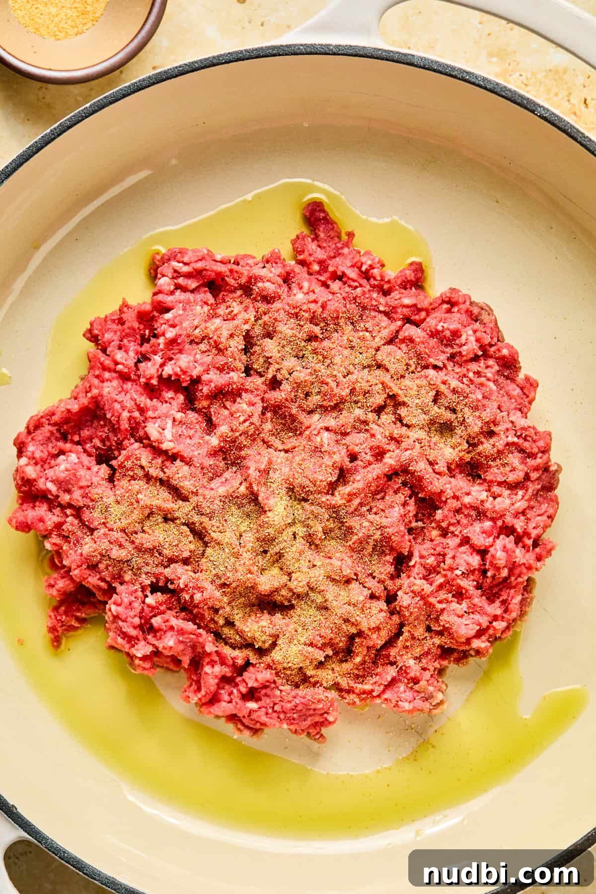 Philly Cheesesteak Rice Bowl Recipe — Savory Steak & Peppers 5 Ground beef in olive oil in skillet with garlic powder sprinkled over top.