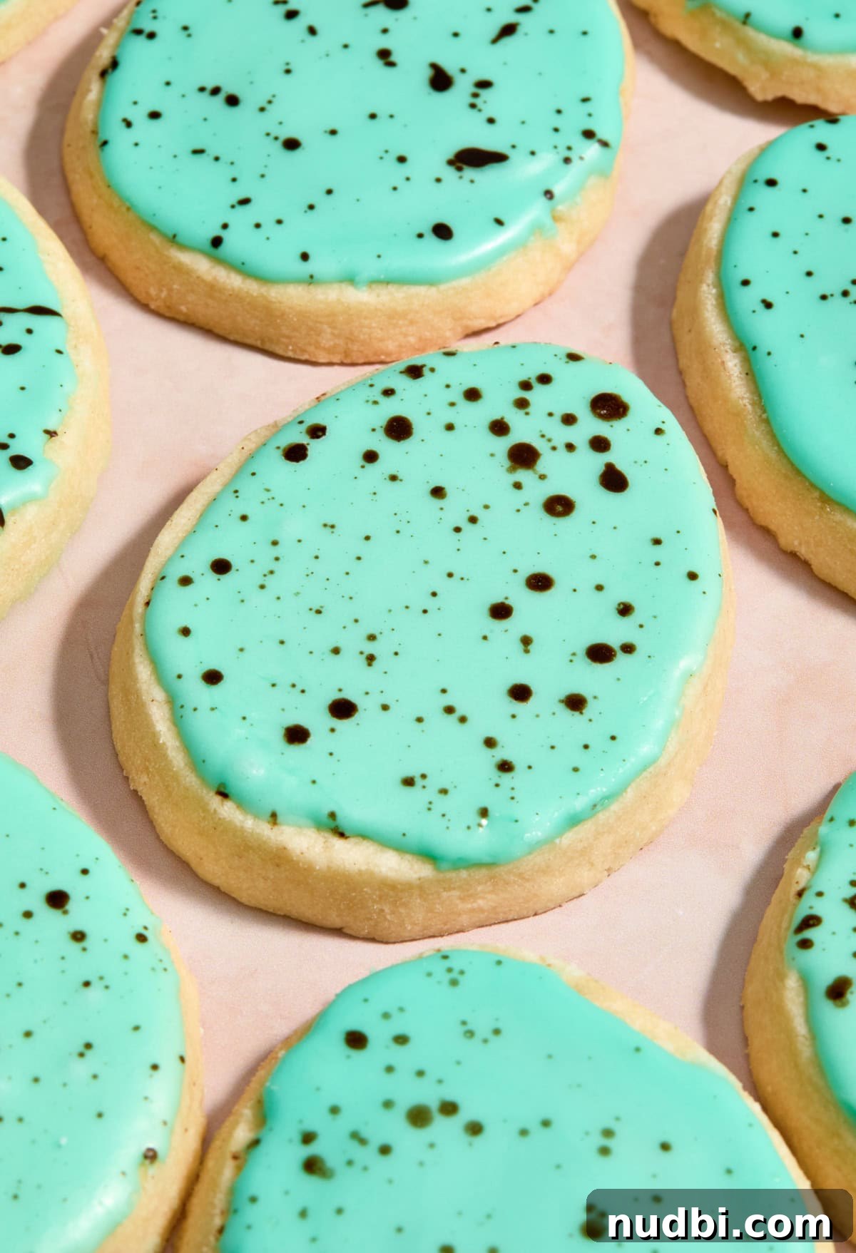 Speckled Easter Egg Shortbread Cookies Recipe 15 Speckled egg cookies on surface.