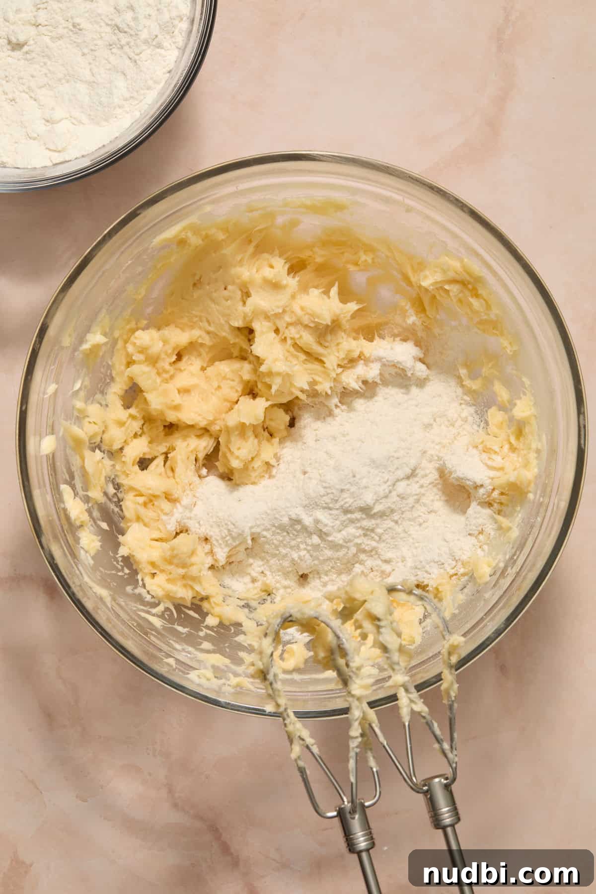 Speckled Easter Egg Shortbread Cookies Recipe 7 Dry ingredients being added to wet ingredients in bowl.