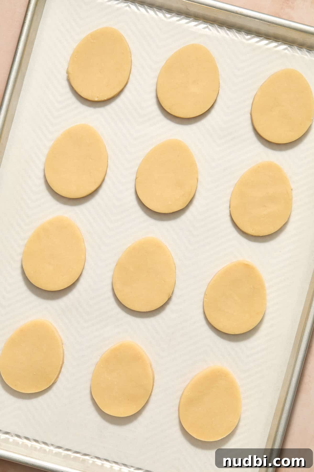 Speckled Easter Egg Shortbread Cookies Recipe 10 Egg shaped shortbread cookie dough cutouts on parchment lined pan.