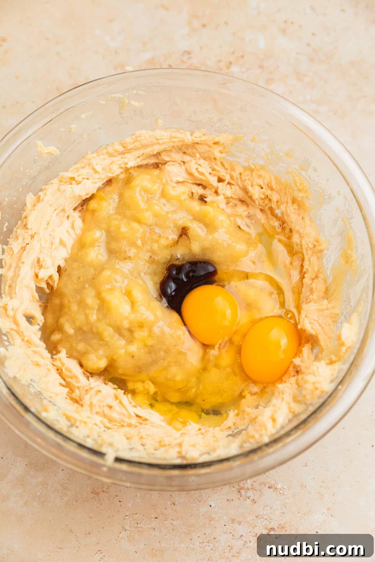 Moist Cinnamon Banana Bread Recipe with Warm Spice Flavor 7 Mashed banana, eggs and vanilla bean paste added to creamed butter and sugar in bowl.