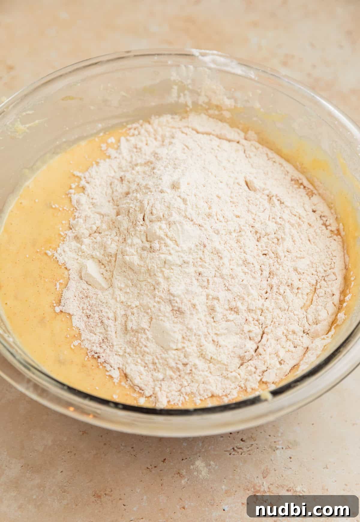 Moist Cinnamon Banana Bread Recipe with Warm Spice Flavor 8 Dry ingredients added to wet ingredients in bowl.q