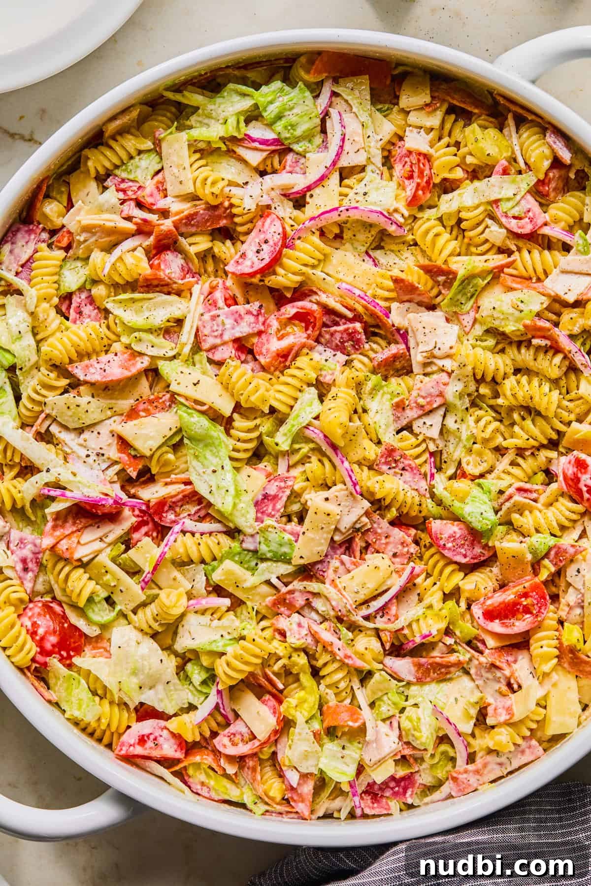 Italian Grinder Pasta Salad Recipe for Perfect Picnic Meals 11 Pasta salad with turkey, pepperoni, salami, lettuce and other ingredients i serving bowl.