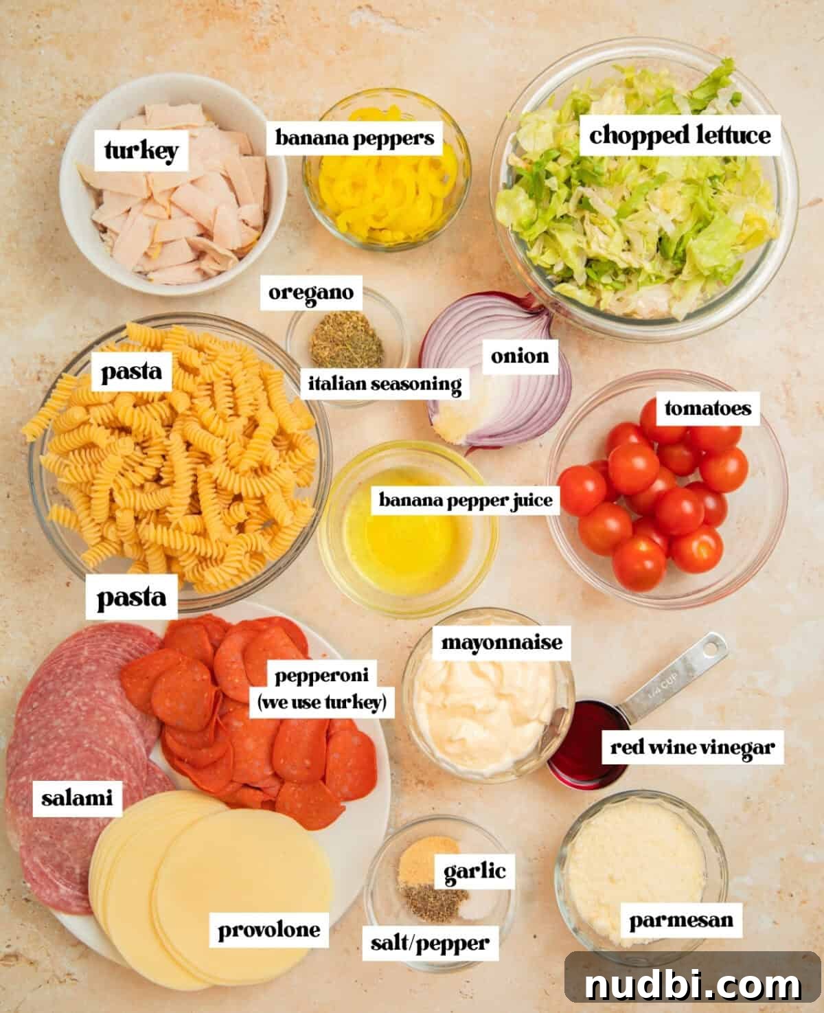 Italian Grinder Pasta Salad Recipe for Perfect Picnic Meals 4 Uncooked pasta, salami, turkey, banana peppers, tomatoes and other labeled ingredients.