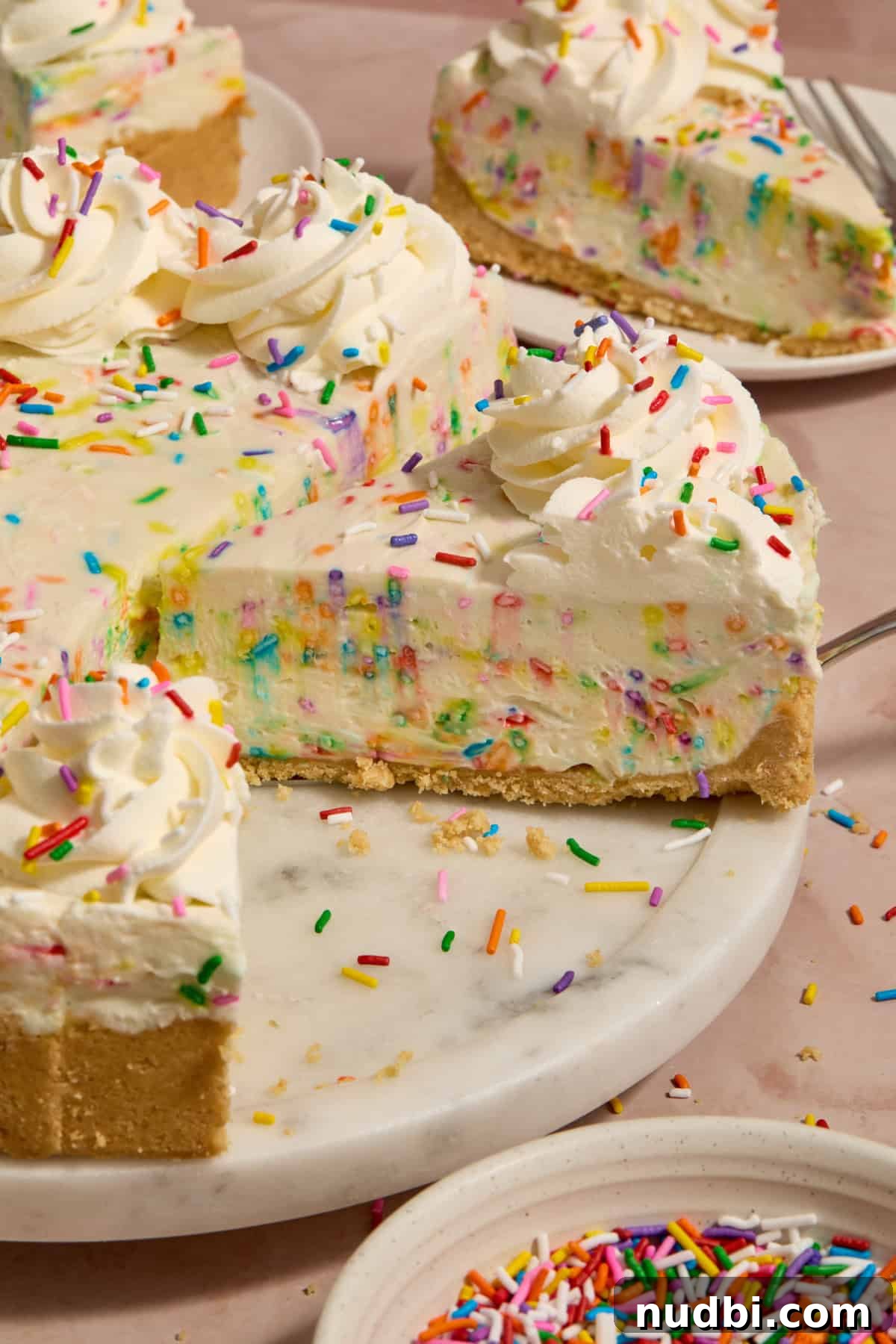 No-Bake Funfetti Cheesecake Recipe for Celebrations 10 Slice of no bake funfetti cheesecake on spatula ready to serve.