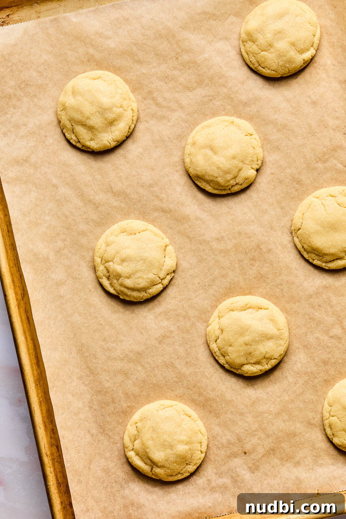 Iced Sugar Cookie Recipe: Soft, Chewy Cookies with Royal Icing 11 Baked sugar cookies on baking sheet.