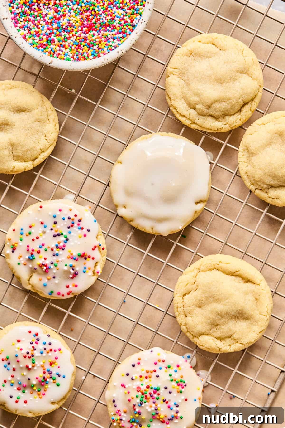 Iced Sugar Cookie Recipe: Soft, Chewy Cookies with Royal Icing 12 Sugar cookies on cooling rack with icing glaze.