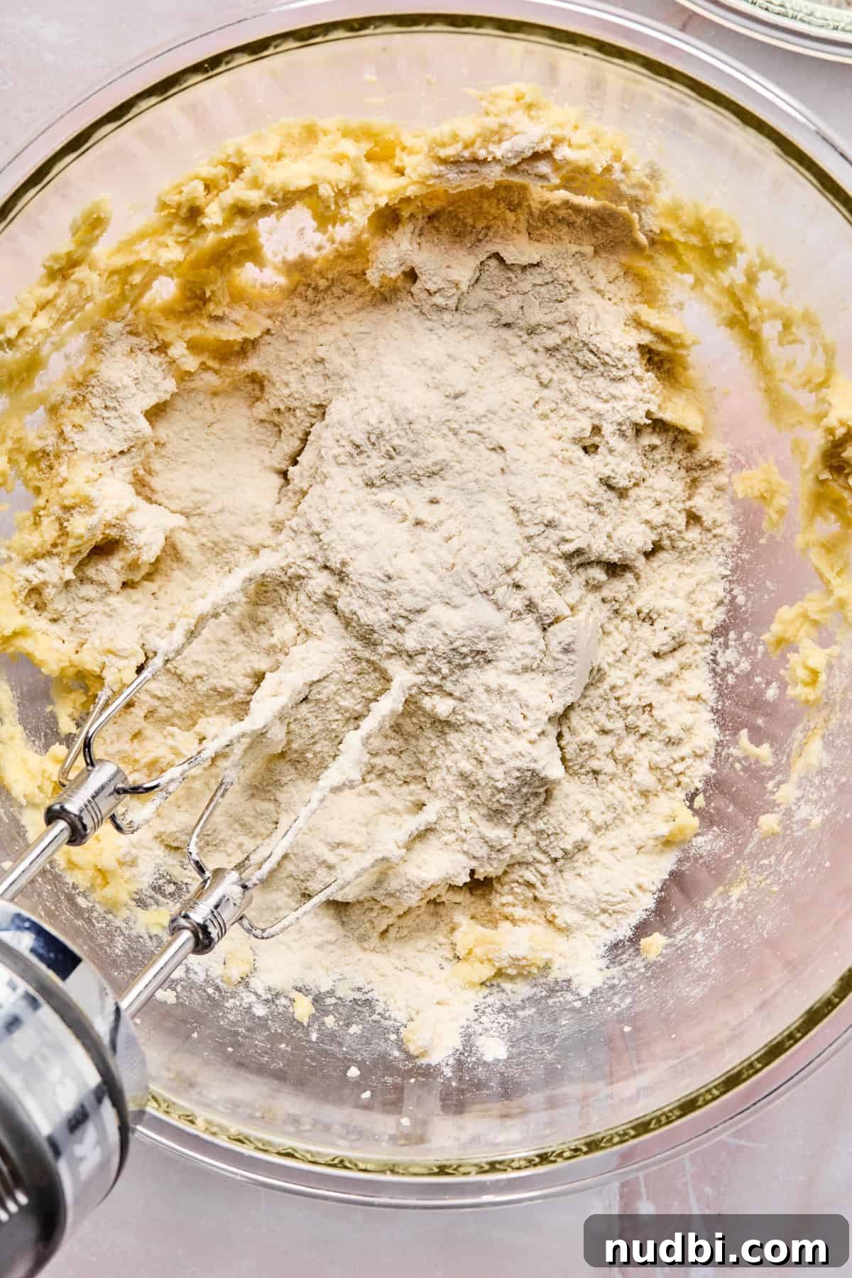 Iced Sugar Cookie Recipe: Soft, Chewy Cookies with Royal Icing 8 Dry ingredients added to wet ingredients in bowl.