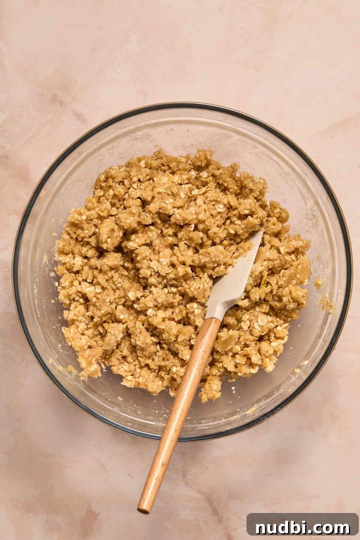 Lemon oat mixture in bowl with spatula.