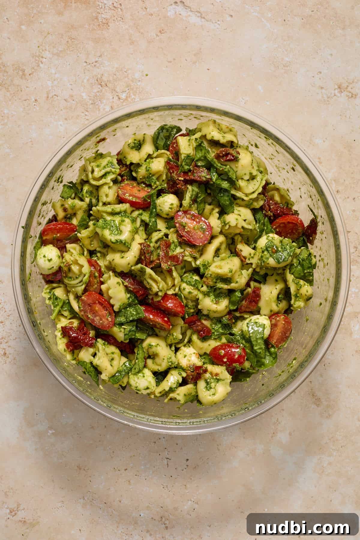 Creamy Tortellini Pesto Salad with Cherry Tomatoes & Spinach 10 Prepared tortellini pesto pasta salad in mixing bowl.