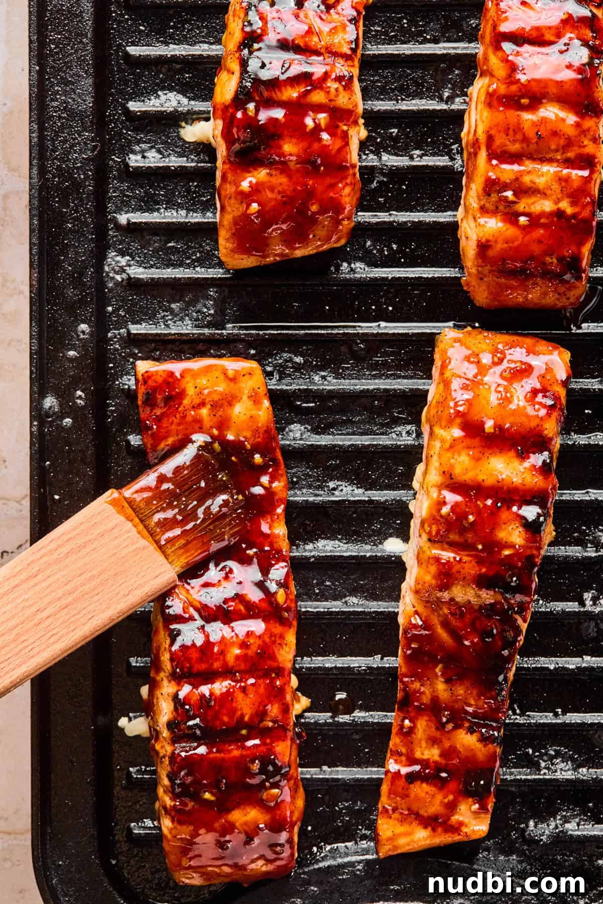 Crispy Grilled Teriyaki Salmon with Sticky Glaze Recipe 10 Grilled salmon with teriyaki sauce being brushed on.