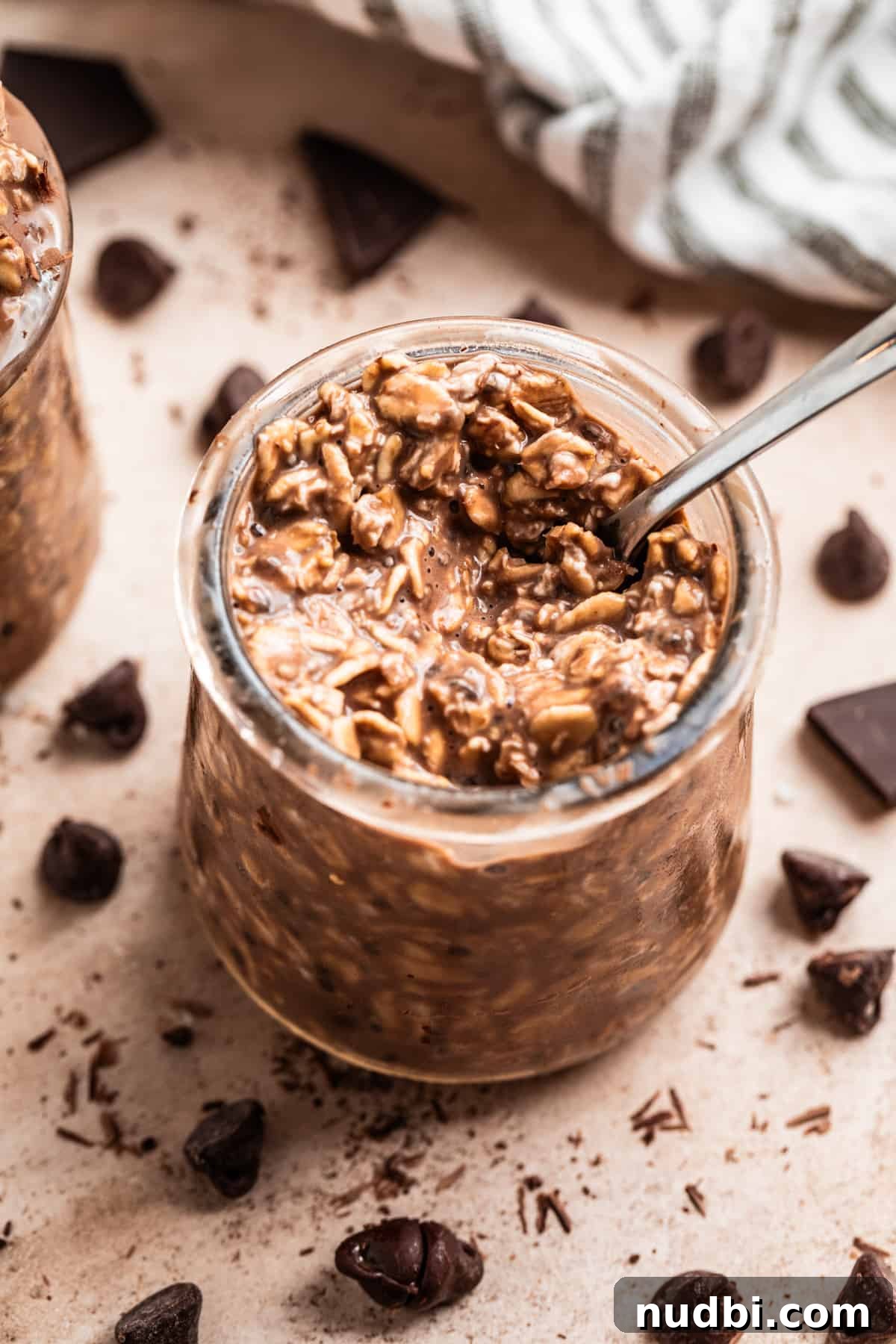 Triple Chocolate Overnight Oats Recipe for Chocolate Lovers 4 Spoon scooping into jar with chocolate overnight oats.