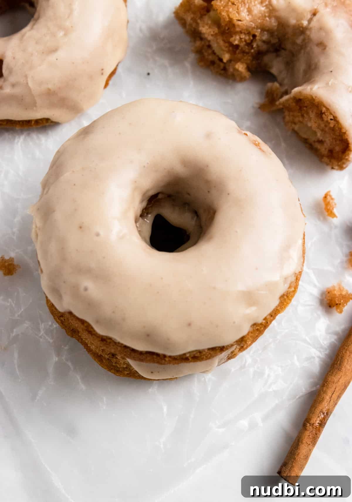 Apple Cider-Glazed Apple Cinnamon Donuts Recipe 8 Glazed donut with cinnamon stick and donut half.