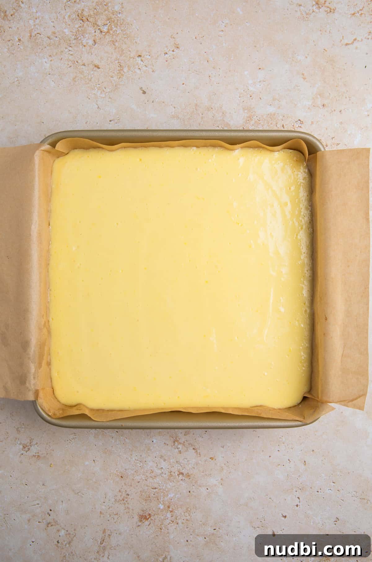 Creamy Lemon Bars with Graham Cracker Crust Recipe 12 Baked lemon bars with graham cracker crust in pan.