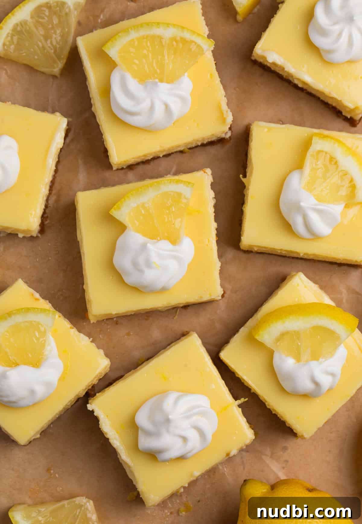 Creamy Lemon Bars with Graham Cracker Crust Recipe 13 Overhead view of lemon bars topped with whipped cream.